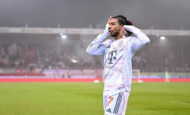 Bayern's Michael Olise celebrates after scoring their side's second goal of the game during the Bundesliga soccer match between FC Heidenheim and Bayern Munich, in Heidenheim, Germany, Sunday Dec. 21, 2025. (Harry Langer/dpa via AP)