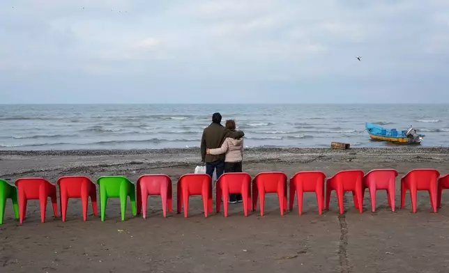People enjoy their time at the beach of the southern coast of the Caspian Sea outside the port city of Bandar Anzali, Iran, Tuesday, Dec. 23, 2025. (AP Photo/Vahid Salemi)