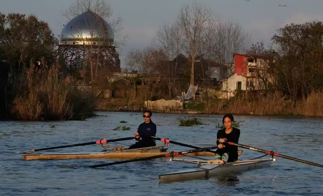 Athletes paddle while training in the Anzali Lagoon as dome of a mosque is seen at background in the southern coast of the Caspian Sea in port city of Bandar Anzali, Iran, Sunday, Dec. 21, 2025. (AP Photo/Vahid Salemi)