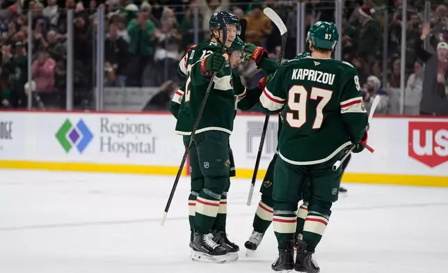 Minnesota Wild left wing Matt Boldy (12) celebrates toward left wing Kirill Kaprizov (97) after scoring a goal during the first period of an NHL hockey game against the Edmonton Oilers, Saturday, Dec. 20, 2025, in St. Paul, Minn. (AP Photo/Abbie Parr)