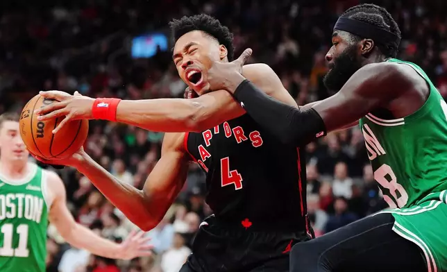 Toronto Raptors' Scottie Barnes (4) is fouled by Boston Celtics' Neemias Queta, right, during first-half NBA basketball game action in Toronto, Saturday, Dec. 20, 2025. (Frank Gunn/The Canadian Press via AP)