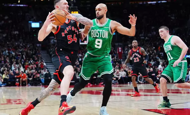 Toronto Raptors' Sandro Mamukelashvili (54) drives as Boston Celtics' Derrick White (9) defends during first-half NBA basketball game action in Toronto, Saturday, Dec. 20, 2025. (Frank Gunn/The Canadian Press via AP)