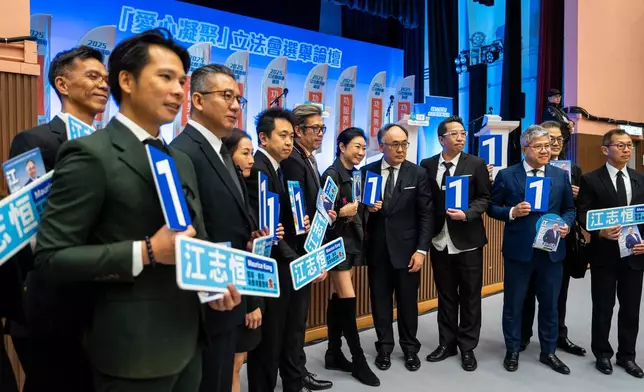 Kong Chi Hang, fifth from right, candidate of the Legislative Council Catering functional constituency election, poses for photographs with supporters at a forum in Hong Kong on Wednesday, Dec. 3, 2025. (AP Photo/Chan Long Hei)