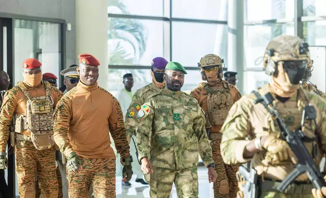 Burkina Faso's President Captain Ibrahim Traoré, second left, walks alongside Mali's President General Assimi Goïta during the Alliance of Sahel States (AES) second summit on security and development in Bamako, Mali, Tuesday, Dec. 23, 2025. (Mali Government Information Center via AP)