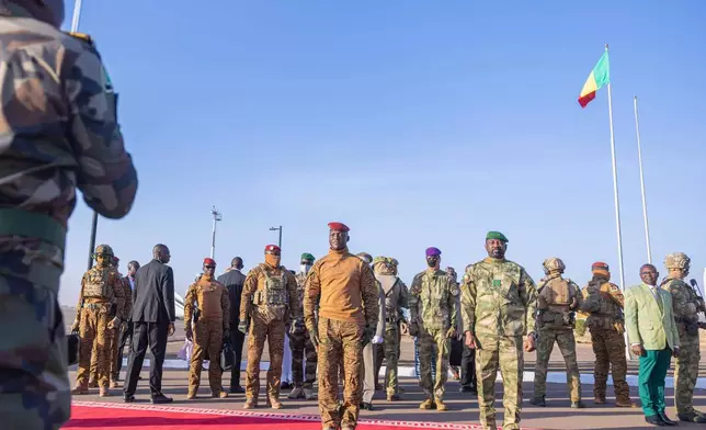 Burkina Faso's President Captain Ibrahim Traoré, left, and Mali's President General Assimi Goïta stand during a welcome ceremony of the Confederation of the Alliance of Sahel States (AES), to the second summit on security and development in Bamako, Mali, Tuesday, Dec. 23, 2025. (Mali Government Information Center via AP)