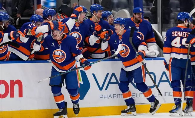 New York Islanders' Casey Cizikas (53), front left, celebrates his empty net goal with teammates during the third period of an NHL hockey game against the Colorado Avalanche, Thursday, Dec. 4, 2025, in Elmont, N.Y. (AP Photo/Seth Wenig)