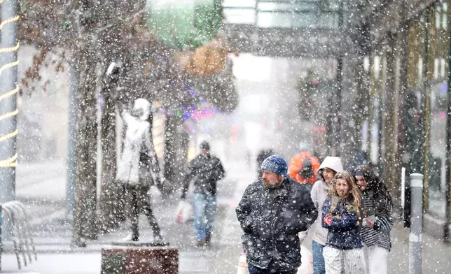 Heavy snow falls along Nicollet Mall Sunday Dec.28, 2025 in Minneapolis. (Jerry Holt /Star Tribune via AP)