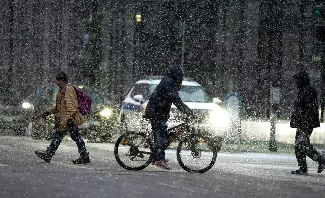 People cross 7th street in the heavy snow on Sunday Dec. 28, 2025 in downtown Minneapolis. (Jerry Holt /Star Tribune via AP)
