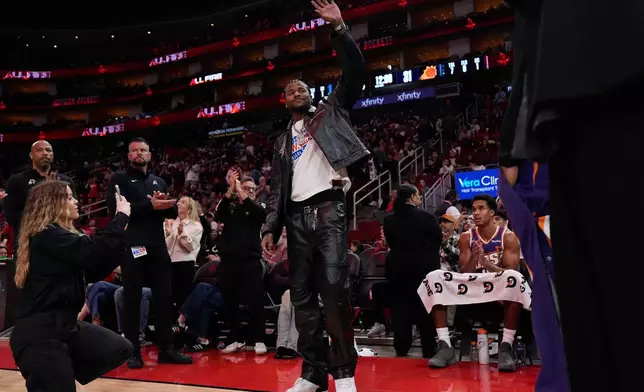 Phoenix Suns guard Jalen Green waves after a tribute video plays during the first half of an NBA basketball game against the Houston Rockets in Houston, Friday, Dec. 5, 2025. (AP Photo/Ashley Landis)