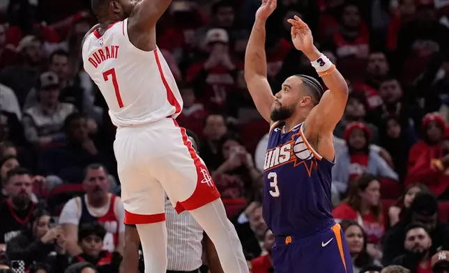 Houston Rockets forward Kevin Durant (7) shoots against Phoenix Suns forward Dillon Brooks (3) during the first half of an NBA basketball game in Houston, Friday, Dec. 5, 2025. (AP Photo/Ashley Landis)