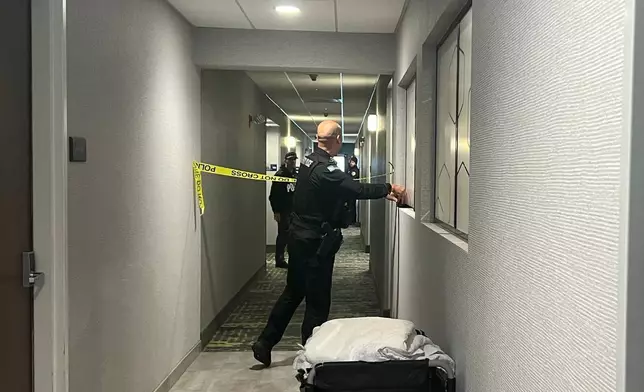 Police tape off hotel rooms where the person of interest was arrested in a shooting, Sunday, Dec. 14, 2025, in Coventry, R.I. (AP Photo/Kimberlee Kruesi)