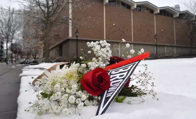 A bouquet of flowers rests on snow, Sunday, Dec. 14, 2025, on the campus of Brown University not far from where a shooting took place, in Providence, R.I. (AP Photo/Steven Senne)