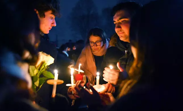 People hold candles during a vigil, Sunday, Dec. 14, 2025, in Providence, R.I., for those injured or killed during the Saturday shooting on Brown University campus. (AP Photo/Steven Senne)
