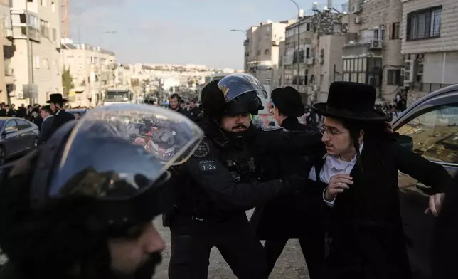 Israeli police officers scuffle with young Ultra-Orthodox Jewish protesters during a violent disturbance in Jerusalem, Thursday, Dec. 18, 2025. (AP Photo/Mahmoud Illean)