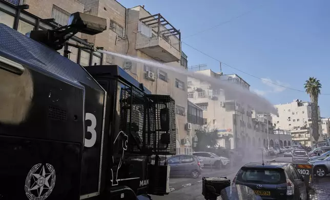 Israeli police shoot a water canon as they work to restore order during a violent disturbance by Ultra-Orthodox Jewish protesters in Jerusalem, Thursday, Dec. 18, 2025. (AP Photo/ Mahmoud Illean)