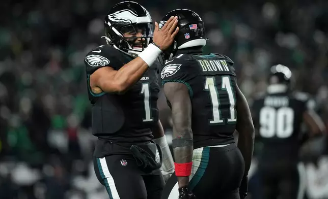 Philadelphia Eagles wide receiver A.J. Brown (11), right, celebrates his touchdown with quarterback Jalen Hurts (1) during the second half of an NFL football game against the Chicago Bears, Friday, Nov. 28, 2025, in Philadelphia. (AP Photo/Matt Slocum)
