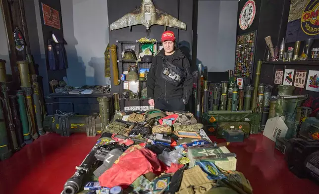 Ukrainian street artist Maxim Kilderov stands with a collection of battlefield artifacts documenting Russia's invasion of Ukraine in his private museum in Kyiv, Ukraine, Tuesday, Dec. 16, 2025. (AP Photo/Efrem Lukatsky)