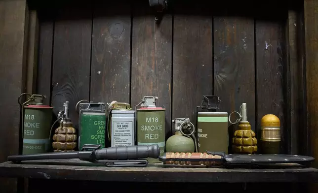 Knives, grenades and smoke canisters are on display at a private collection of battlefield items kept by the Ukrainian street artist Maxim Kilderov in Kyiv, Ukraine on Friday, Dec. 12, 2025. (AP Photo/Efrem Lukatsky)