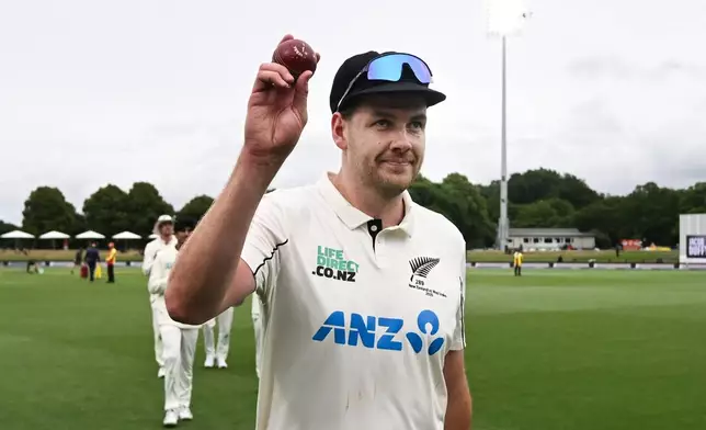 New Zealand's Jacob Duffy hold up the ball after taking 5 wickets against the West Indies during the second day of their cricket test match in Christchurch, New Zealand, Wednesday, Dec. 3, 2025. (Andrew Cornaga/Photosport via AP)
