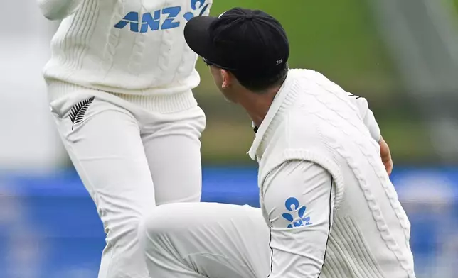New Zealand's Kane Williamson, left, congratulates teammate Will Young after Young took a catch to dismiss West Indies' John Campbell during their cricket test match in Christchurch, New Zealand, Wednesday, Dec. 3, 2025. (Andrew Cornaga/Photosport via AP)