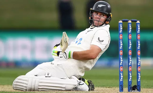New Zealand's Tom Latham kneels while batting against the West Indies during the second day of their cricket test match in Christchurch, New Zealand, Wednesday, Dec. 3, 2025. (Chris Symes/Photosport via AP)