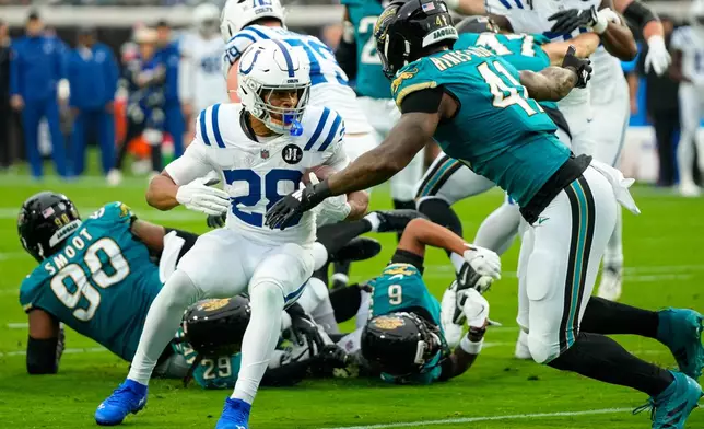 Jacksonville Jaguars defensive end Josh Hines-Allen (41) tackles Indianapolis Colts running back Jonathan Taylor (28) during the first half of an NFL football game, Sunday, Dec. 7, 2025, in Jacksonville, Fla. (AP Photo/John Raoux)