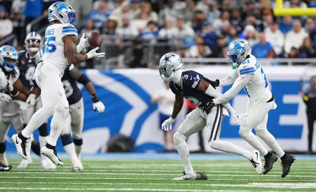 Detroit Lions linebacker Derrick Barnes, left, intercepts a pass intended for Dallas Cowboys wide receiver George Pickens (3) as Lions teammate Amik Robertson helps defend during the second half of an NFL football game Thursday, Dec. 4, 2025, in Detroit. (AP Photo/Ryan Sun)