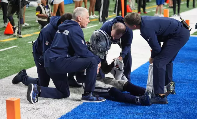 Dallas Cowboys wide receiver Ceedee Lamb is tended to by trainers during the second half of an NFL football game against the Detroit Lions Thursday, Dec. 4, 2025, in Detroit. (AP Photo/Paul Sancya)