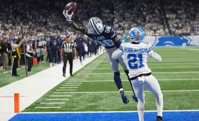 Dallas Cowboys wide receiver Ceedee Lamb (88) attempts a catch in front of Detroit Lions cornerback Amik Robertson (21) during the second half of an NFL football game Thursday, Dec. 4, 2025, in Detroit. (AP Photo/Paul Sancya)