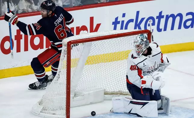Winnipeg Jets' Logan Stanley (64) celebrates his goal on Washington Capitals goaltender Logan Thompson (48) during first period NHL game in Winnipeg on Saturday, Dec. 13, 2025. (John Woods/The Canadian Press via AP)