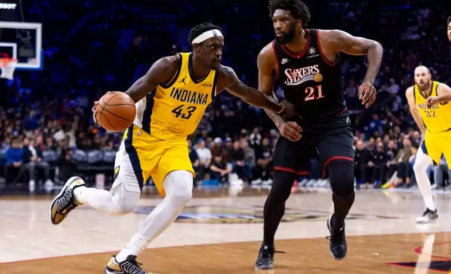 Indiana Pacers' Pascal Siakam, left, drives to the basket against Philadelphia 76ers' Joel Embiid, right, during the second half of an NBA basketball game, Friday, Dec. 12, 2025, in Philadelphia. (AP Photo/Chris Szagola)