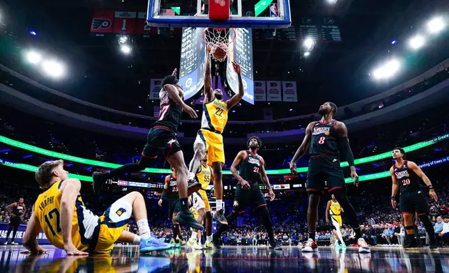 Indiana Pacers' Isaiah Jackson (22) puts back the shot that teammate Johnny Furphy, bottom left, missed with Philadelphia 76ers' VJ Edgecombe, top left, defending. during the first half of an NBA basketball game, Friday, Dec. 12, 2025, in Philadelphia. (AP Photo/Chris Szagola)