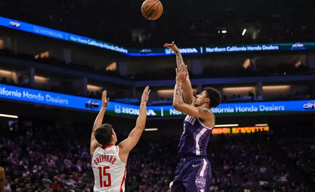 Sacramento Kings guard Nique Clifford (5) attempts a shot over Houston Rockets guard Reed Sheppard (15) during the first half an NBA basketball game, Sunday, Dec. 21, 2025, in Sacramento, Calif. (AP Photo/Justine Willard)