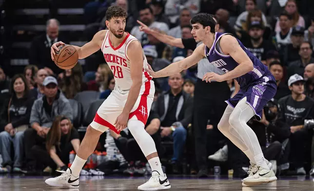 Houston Rockets center Alperen Sengun (28) dribbles against Sacramento Kings center Maxime Raynaud, right, during the first half an NBA basketball game, Sunday, Dec. 21, 2025, in Sacramento, Calif. (AP Photo/Justine Willard)