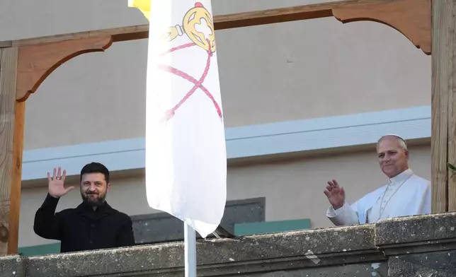 Ukraine's President Volodymyr Zelenskyy and Pope Leo XIV wave to journalists during their meeting in Castel Gandolfo, Italy, Tuesday, Dec. 9, 2025. (AP Photo/Andrew Medichini)