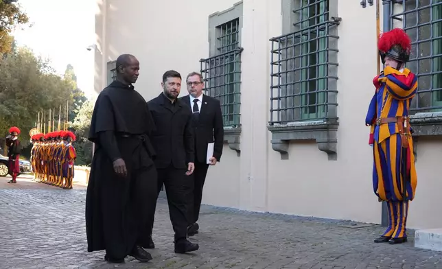 Ukraine President Volodymyr Zelenskyy, center, walks past Swiss guards as he arrives to meet with Pope Leo XIV in Castel Gandolfo, Italy, Tuesday, Dec. 9, 2025. (AP Photo/Andrew Medichini)