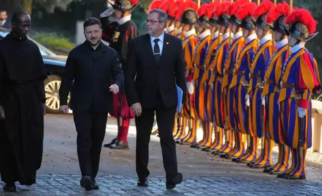 Ukraine President Volodymyr Zelenskyy, center, walks past Swiss guards as he arrives to meet with Pope Leo XIV in Castel Gandolfo, Italy, Tuesday, Dec. 9, 2025. (AP Photo/Andrew Medichini)