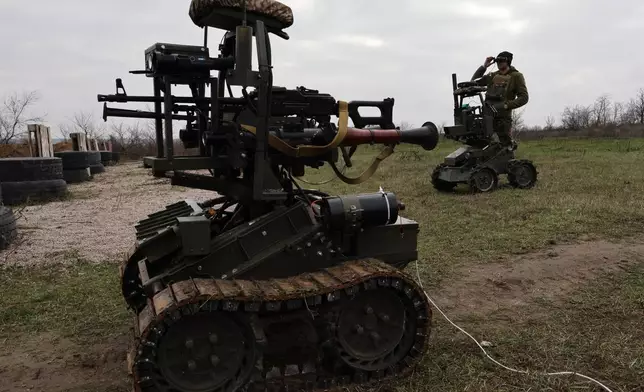 In this photo provided by Ukraine's 65th Mechanized Brigade press service, a soldier tests land drones in Zaporizhzhia region, Ukraine, Saturday, Dec. 6, 2025, (Andriy Andriyenko/Ukraine's 65th Mechanized Brigade via AP)