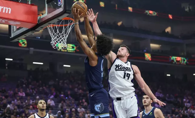 Memphis Grizzlies forward Jaylen Wells (0) dunks past Sacramento Kings center Drew Eubanks (19) during the first half of an NBA basketball game Sunday, Nov. 30, 2025, in Sacramento, Calif. (AP Photo/Sara Nevis)