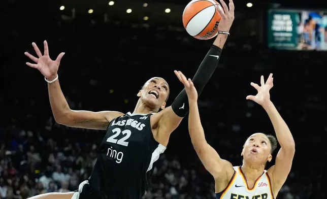 FILE - Las Vegas Aces center A'ja Wilson (22) grabs a rebound over Indiana Fever guard Aerial Powers (23) during the second half of Game 2 of a WNBA basketball playoff semifinals series Tuesday, Sept. 23, 2025, in Las Vegas. (AP Photo/John Locher, File)