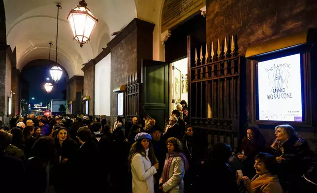 People queue at the San Carlo Theatre, in Naples, Italy, to attend at the general rehearsal of Ennio Morricone's only opera, Partenope, Thursday, Dec. 11, 2025. (AP Photo/Salvatore Laporta)