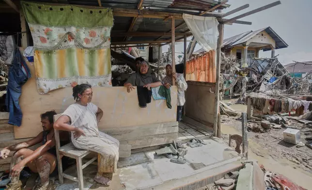 Survivors take shelter at a makeshift hut at an area devastated by flash flooding in Aceh Tamiang on Sumatra Island, Indonesia, Friday, Dec. 5, 2025. (AP Photo/Binsar Bakkara)
