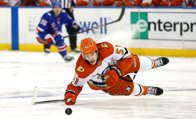 Anaheim Ducks defenseman Olen Zellweger (51) falls while playing the puck against the New York Rangers during the first period of an NHL hockey game Monday, Dec 15, 2025, in New York. (AP Photo/Noah K. Murray)