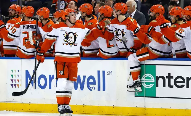 Anaheim Ducks defenseman Jackson Lacombe, front, celebrates with teammates after scoring against the New York Rangers during the second period of an NHL hockey game Monday, Dec 15, 2025, in New York. (AP Photo/Noah K. Murray)
