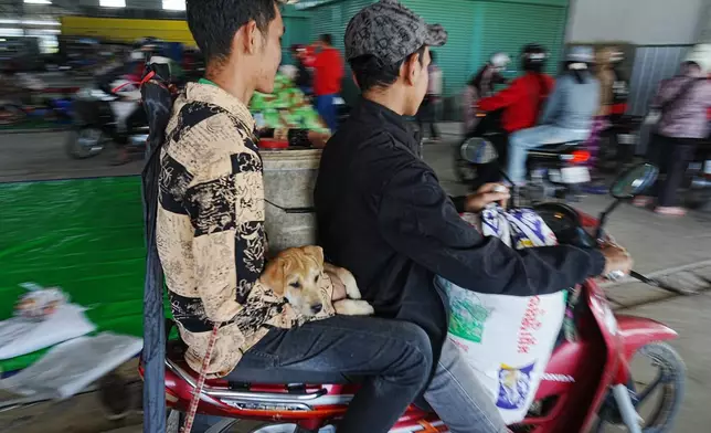 Local people take refuge in Prey Chamkar Ta Doak market in Banteay Meanchey province in Cambodia, near the border with Thailand, Tuesday, Dec. 9, 2025. (AP Photo/Heng Sinith)