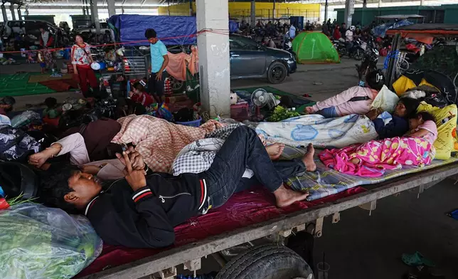 Local people take refuge in Prey Chamkar Ta Doak market in Banteay Meanchey province in Cambodia, near the border with Thailand, Tuesday, Dec. 9, 2025. (AP Photo/Heng Sinith)