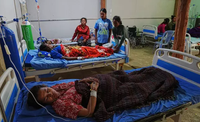 Evacuated people lie on beds at a medical health center as they take refuge in Batthkoa primary school in Oddar Meanchey province, Cambodia, Wednesday, Dec. 10, 2025, after fleeing homes following a fighting between Thailand and Cambodia over territorial claims. (AP Photo/Heng Sinith)