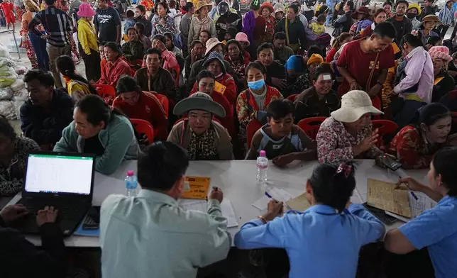 People stay in a line to register at Prey Chamkar Ta Doak market, as they leave the area near the border with Thailand, in Banteay Meanchey province of Cambodia's, Tuesday, Dec. 9, 2025. (AP Photo/Heng Sinith)