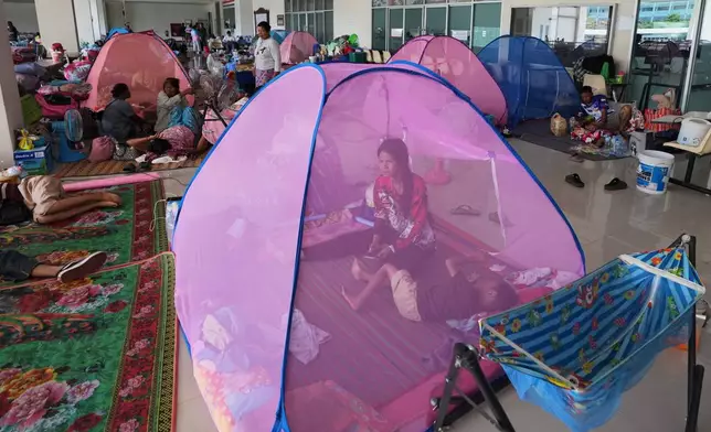Thai residents who fled homes following clashes between Thai and Cambodian soldiers rest at an evacuation center in Surin province, Thailand, Tuesday, Dec. 9, 2025. (AP Photo/Sakchai Lalit)