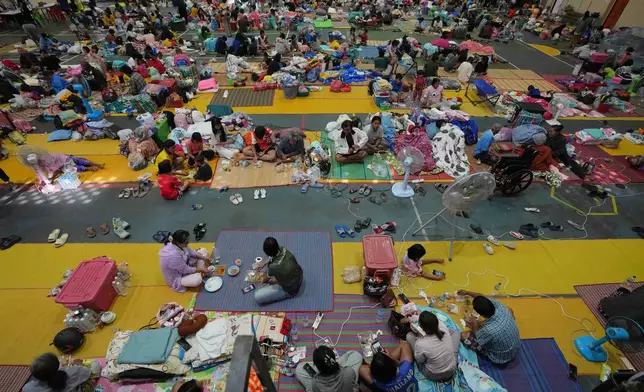 Thai residents who fled homes following the clashes between Thai and Cambodian soldiers, rest at an evacuation center in Surin province, Thailand, Wednesday, Dec. 10, 2025. (AP Photo/Sakchai Lalit)